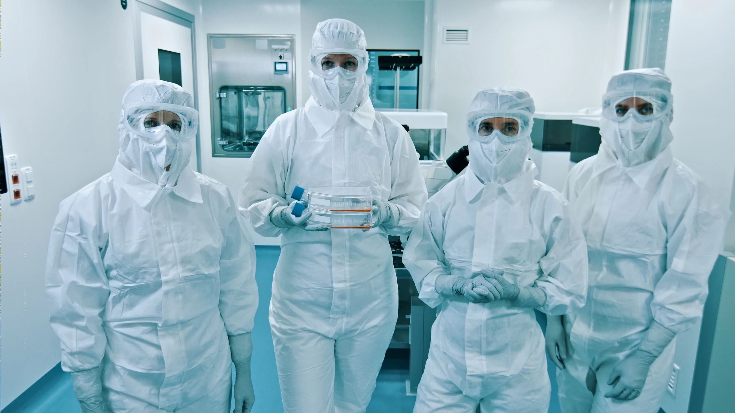 Engineers in protective gear inside a semiconductor cleanroom